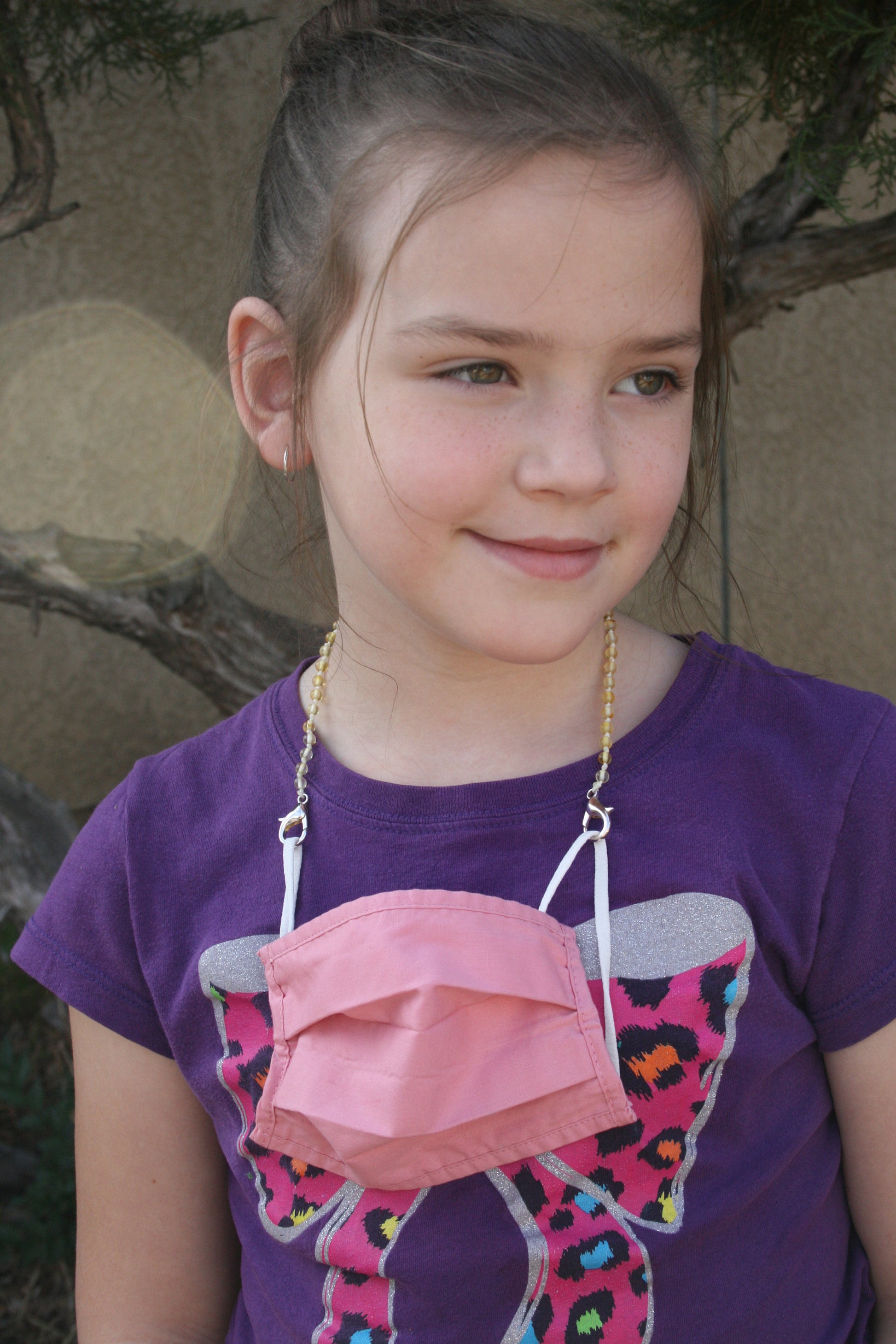 Picture of youth age girl with a mask chain/ glasses chain, you keep up with your glasses or your mask safe when you aren't wearing them. The lobster claw clasp can attach to a mask or hold any pair of glasses or sunglasses with the adjustable soft rubber clasp. For wearing Baltic amber , listing is for any length Mask Chain/ Glasses Chain you need and made with unpolished Baltic amber beads and nickel free, lead free, silver plated lobster clasps. Request a length or style not listed.