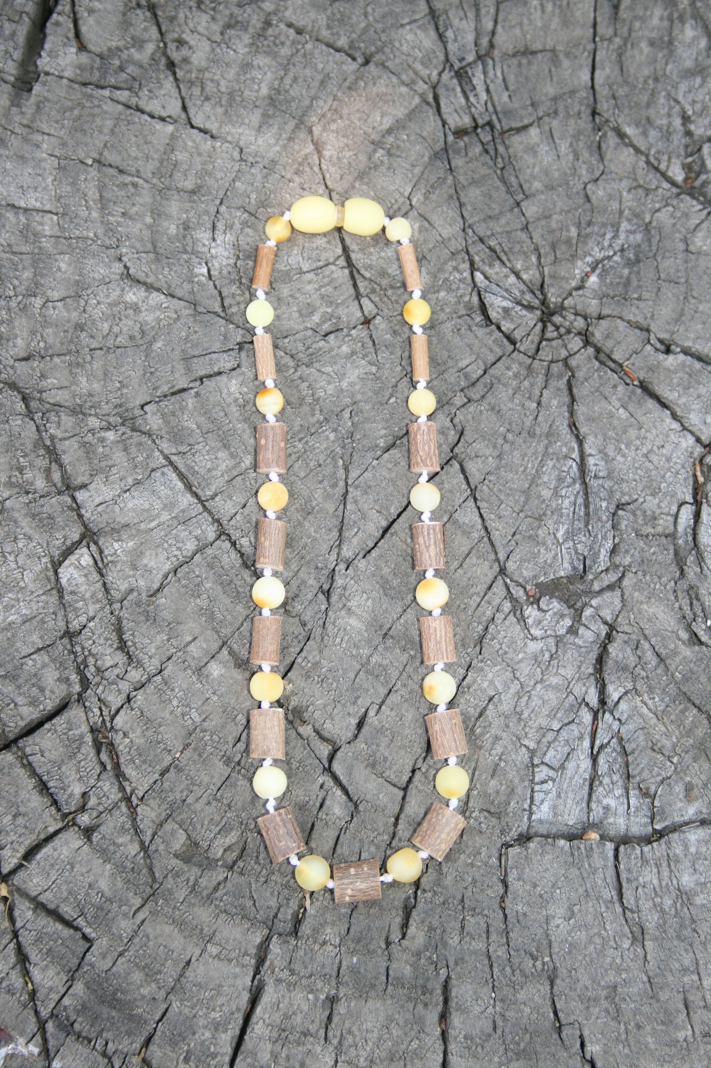 Picture is of hazelwood and milky colored amber. (Jewelry on wooden background)