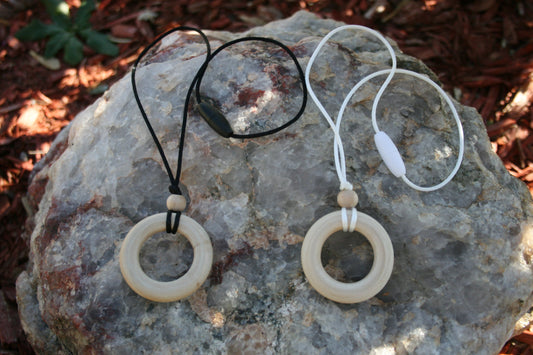 Sensory Necklace Wooden - for Children to Wear and Chew on - Child Sized Nursing Necklace -this 1 3/4" pendant and bead is made from solid Maple hardwoods sourced directly from Oregon, USA! It is strung on a nylon cord and finished off with a plastic clasp designed to pop open when pulled (Jewelry on rock background)