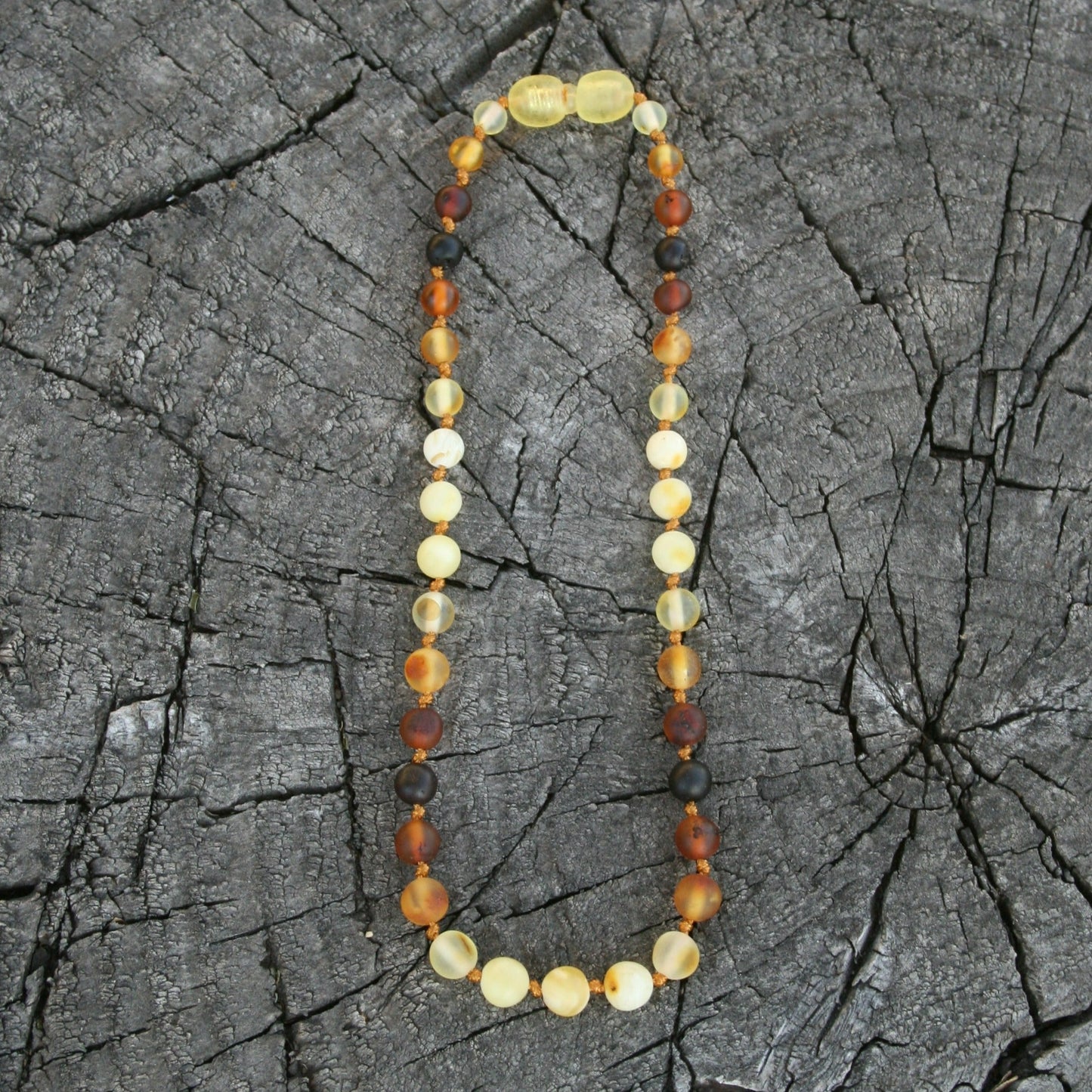 This listing is for any length of round sunrise style Baltic amber jewelry starting at a 4" bracelet all of the way up to a 25" necklace. Longer options are available with our belly chain listing. Everything is strung on nylon cord and hand knotted between each bead. (Jewelry on wooden background)